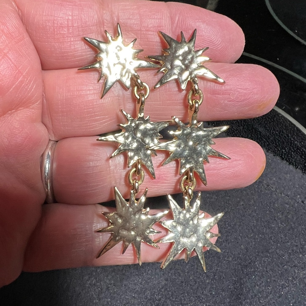 BaubleBar gold tone triple star dangle stud earrings.